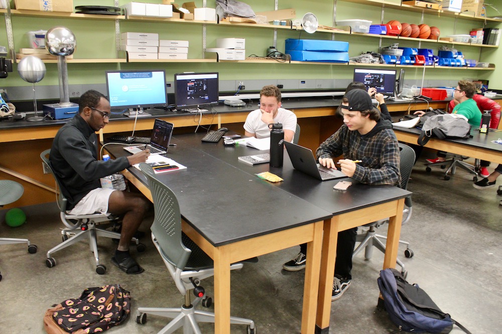 Students at a table working together on a complex project on the computer