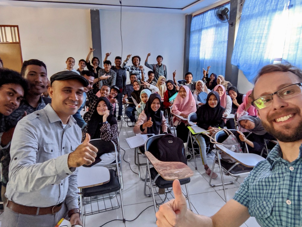 Lev and Halik with a class of Indonesian students, enthusiastically smiling at the camera