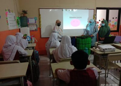 Erlena and Dr. Ishak thank the students for listening, with a projector in the front of the class and students sitting at desks facing the projector screen