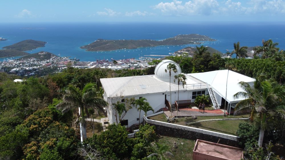 A small observatory building, with a dome housing a telescope, overlooking the Caribbean city of Charlotte Amalie and the deep blue Caribbean Sea