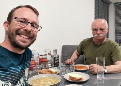 Lev and Ihor at a table with food in a rented apartment