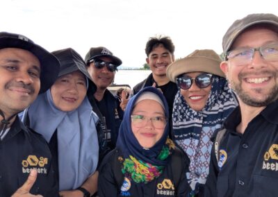 Six Indonesian men and women and one Caucasian man in dark blue buttoned shirts with the Beeworks logo stitched in