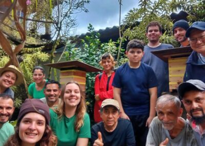 A group of Brazilians standing near boxes full of bees in a rainforest
