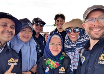 Six Indonesian men and women and one Caucasian man in dark blue buttoned shirts with the Beeworks logo stitched in